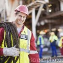 Worker carrying rope on oil rig